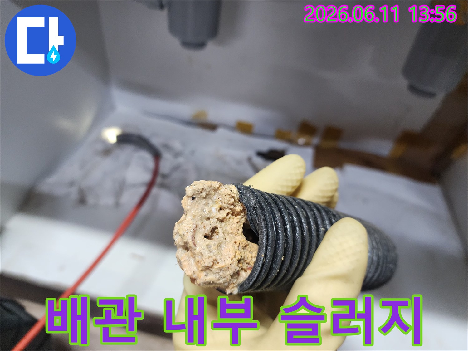 주름진 배관 끝에 붙어 나온 거대한 기름 덩어리 조각