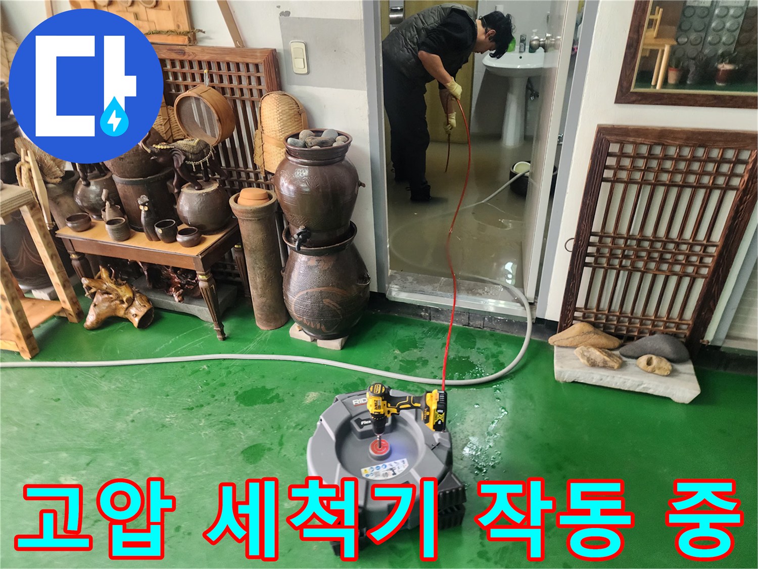 초록색 바닥에 설치된 고압 세척 장비와 호스