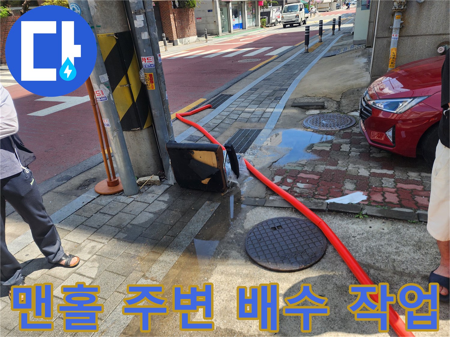 맨홀 뚜껑 주변에-연결된-붉은색 흡입 호스