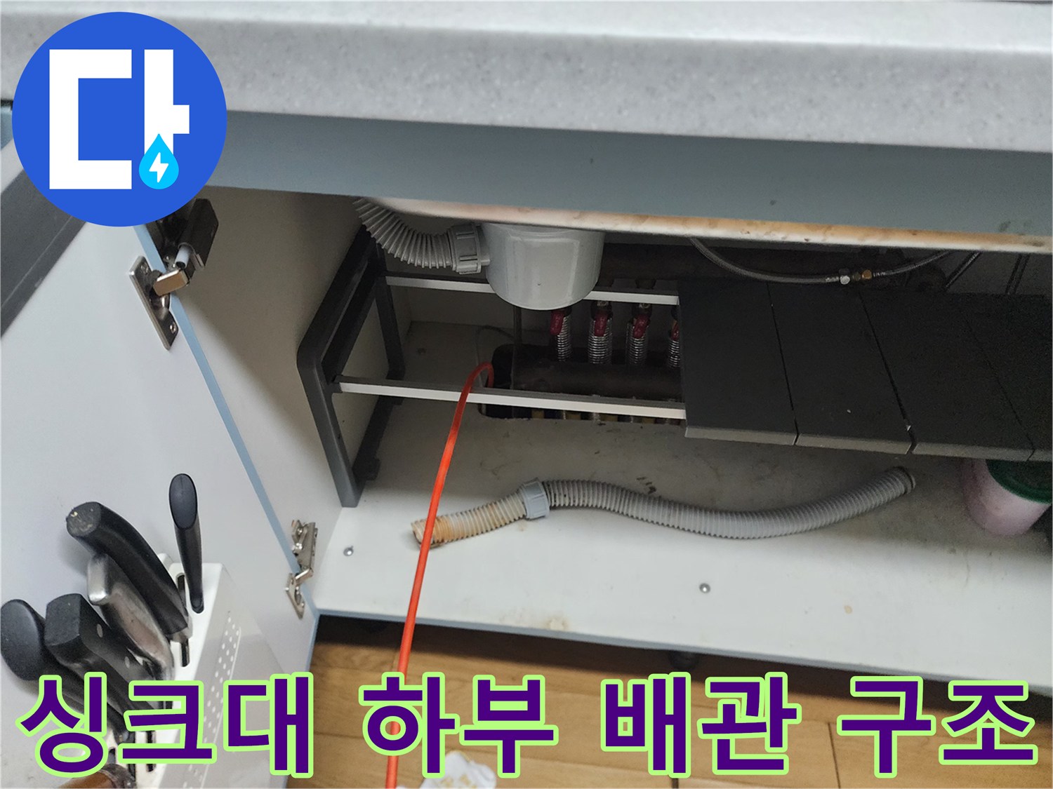 싱크대 아래쪽의 굴곡진 배수 호스와 연결된 관 부위