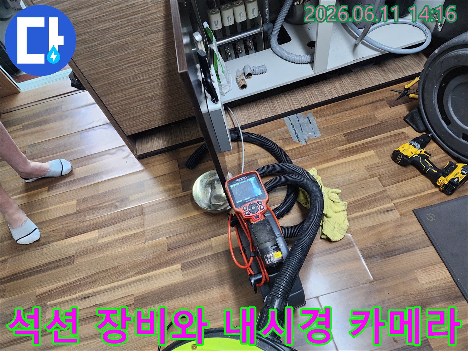 배관 내부의 기름 덩어리를 제거하기 위한 석션기와 내시경 모니터가 놓여 있는 현장입니다.