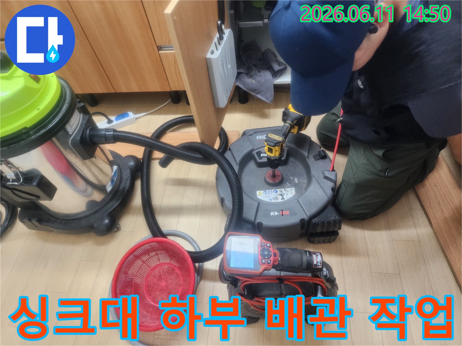 구리 갈매동 싱크대 하부에서 진행 중인 배관 스케일링 장비와 석션기 모습