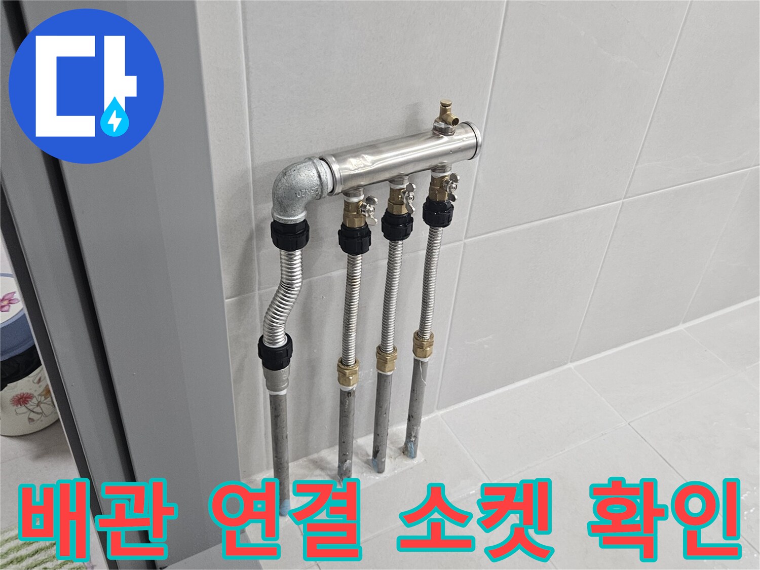벽면 타일 아래-나란히 배치된 배관들의 연결 부위 모습