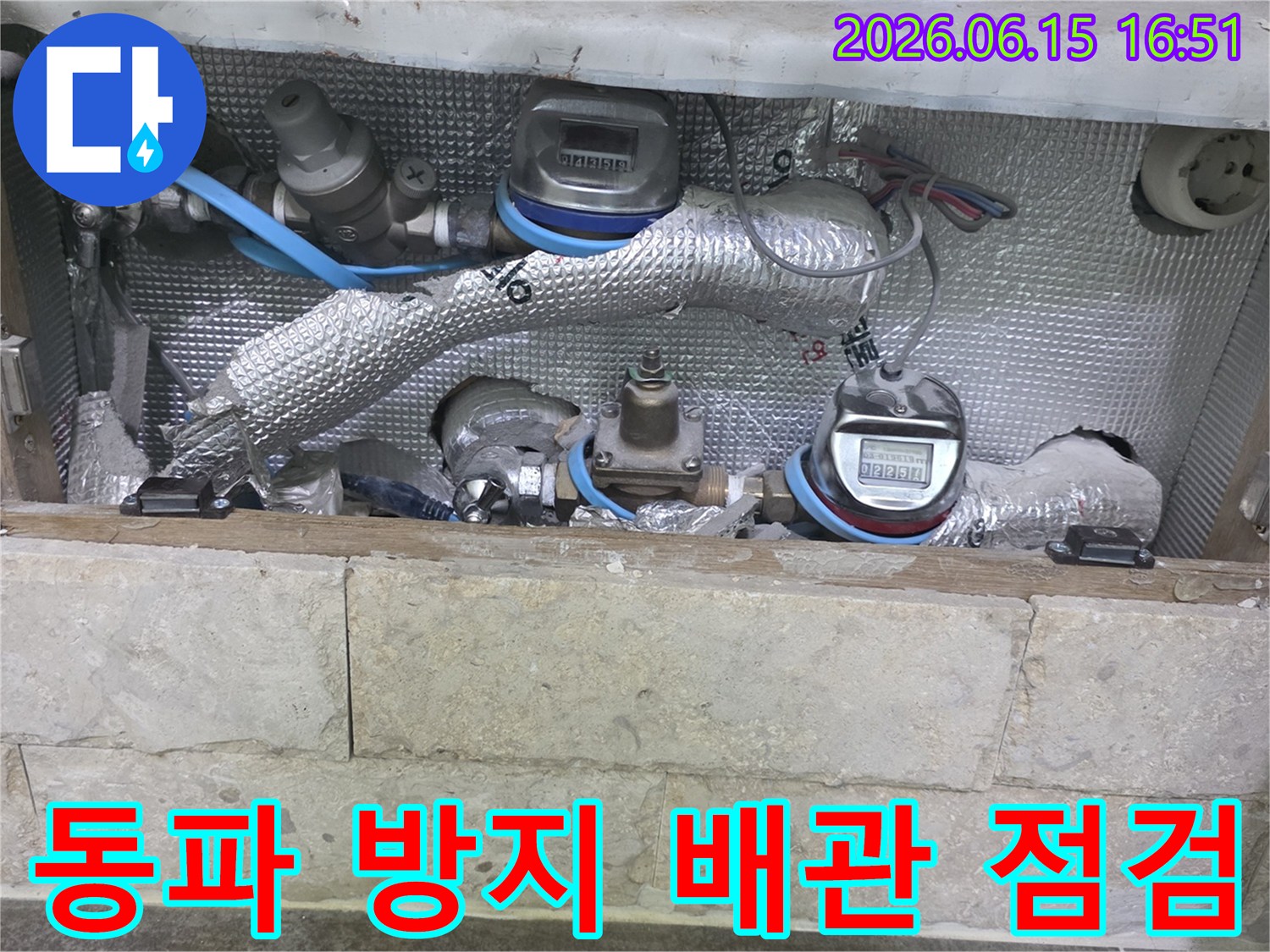 겨울철 동파를 대비하여-보온재로 감싸진 배관과-수도 계량기를-점검하는 현장 사진입니다