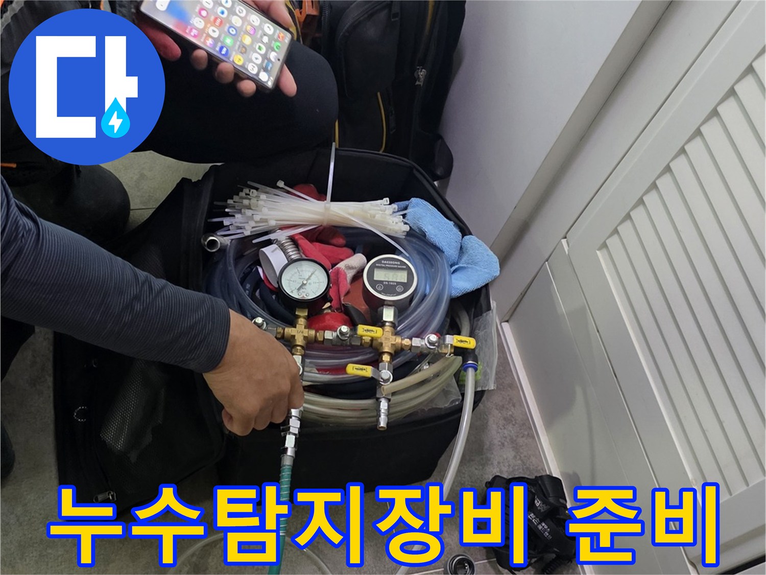 누수 탐지를 위해-전문 장비를 준비하고-스마트폰으로 현장 정보를 확인하는 모습