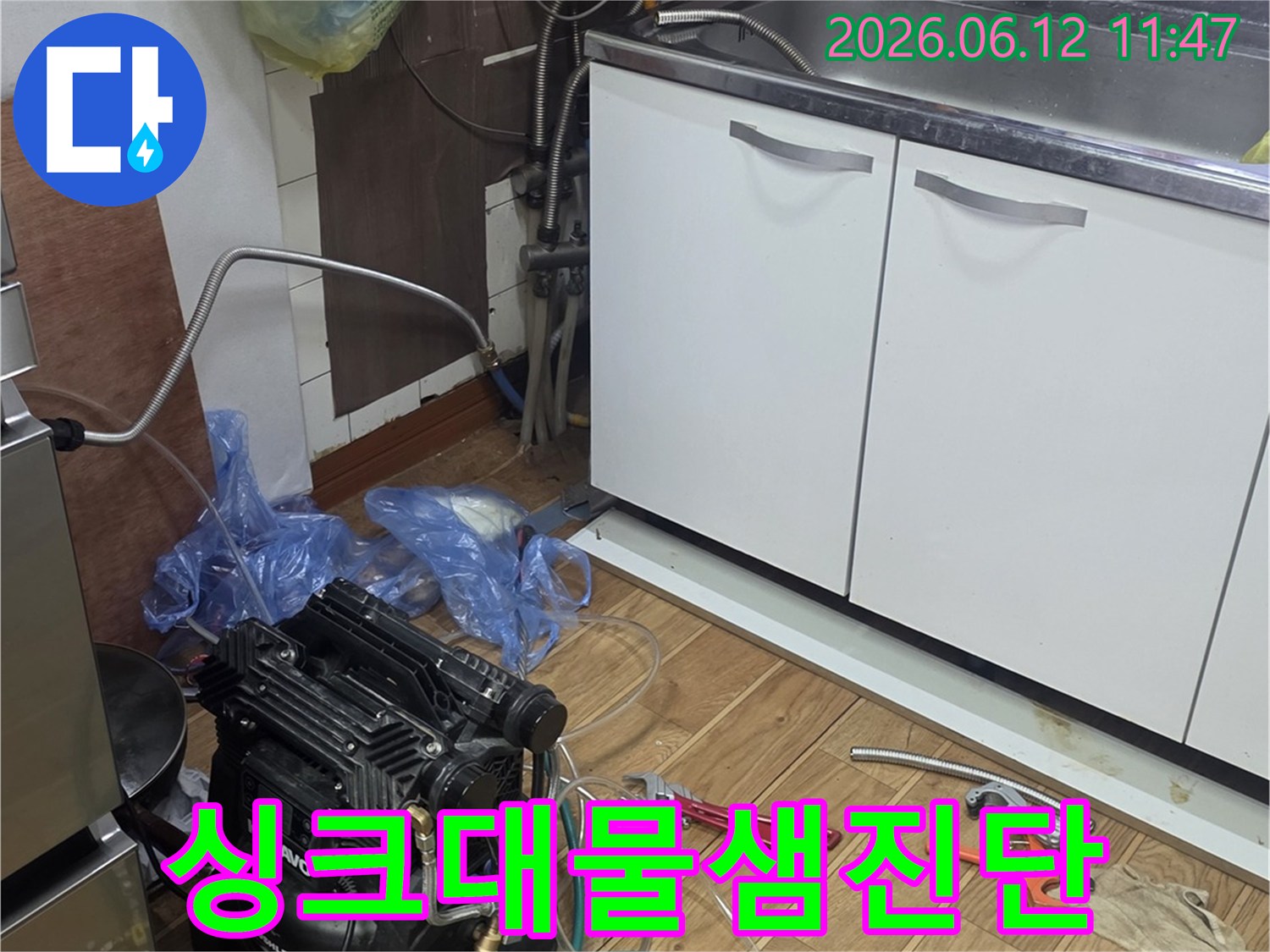 주방 싱크대 아래-누수 진단을 위해-전문 장비와 도구들이-준비된 작업 공간