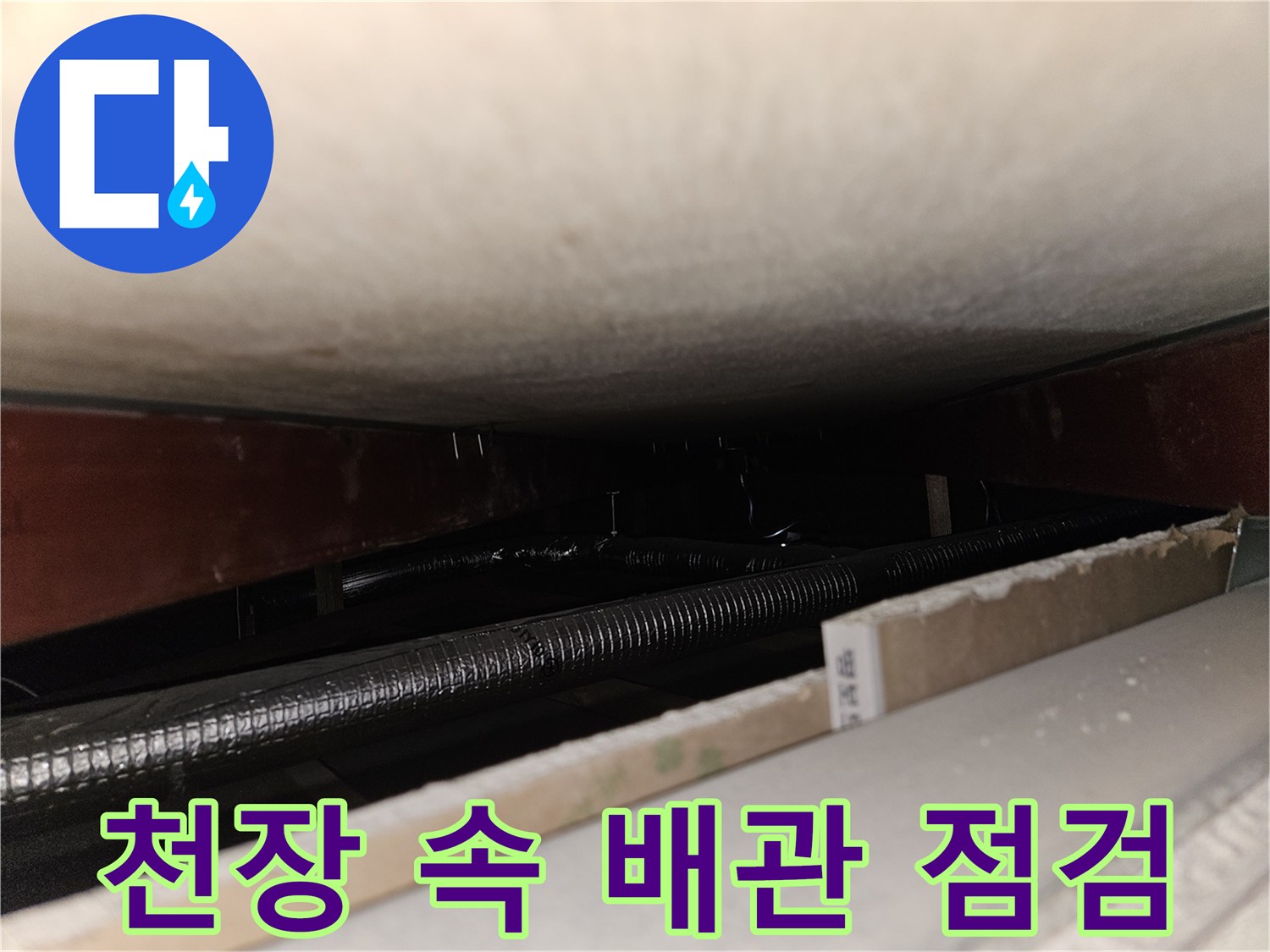 천장 내부 구조물과 은색 주름관의 근접 촬영