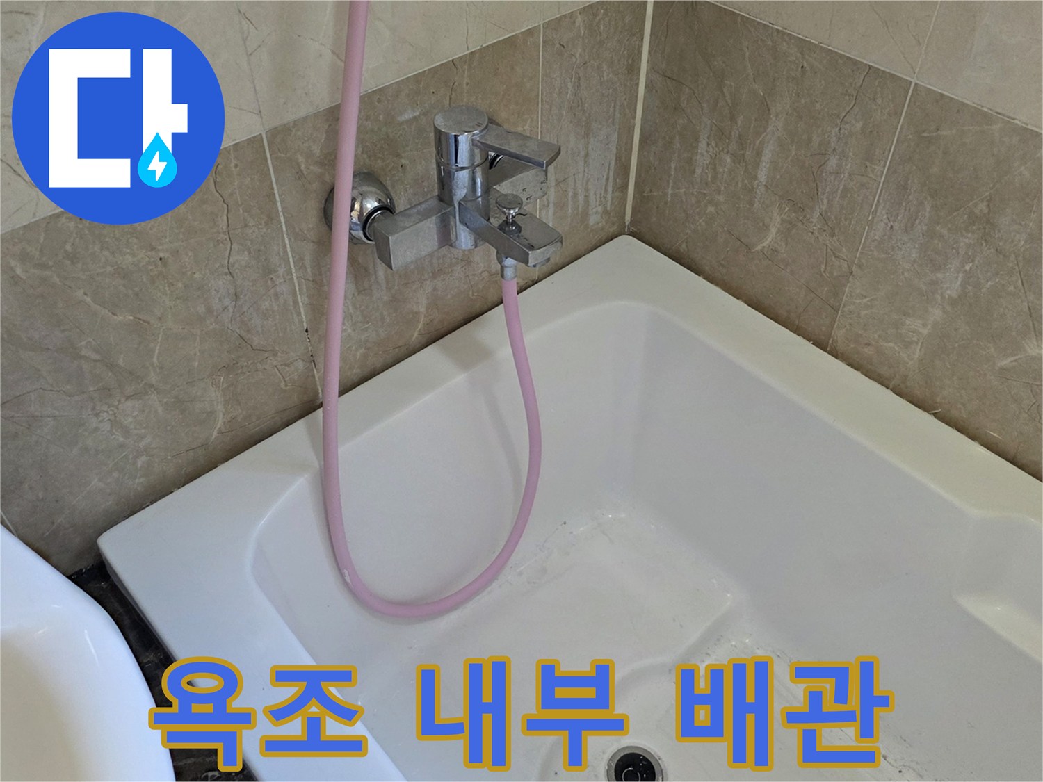 욕조 내부의 수전과 분홍색 호스 연결 부위입니다.