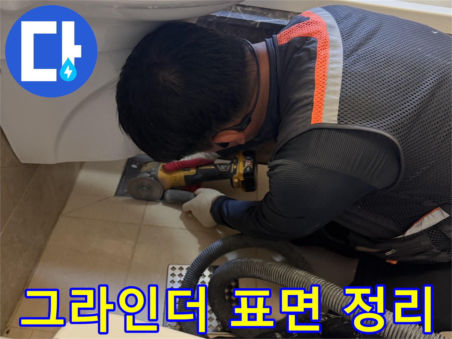 욕조 배수 부위의 노후된 실리콘을 제거하기 위해 그라인더를 사용하는 기술자의 모습입니다.