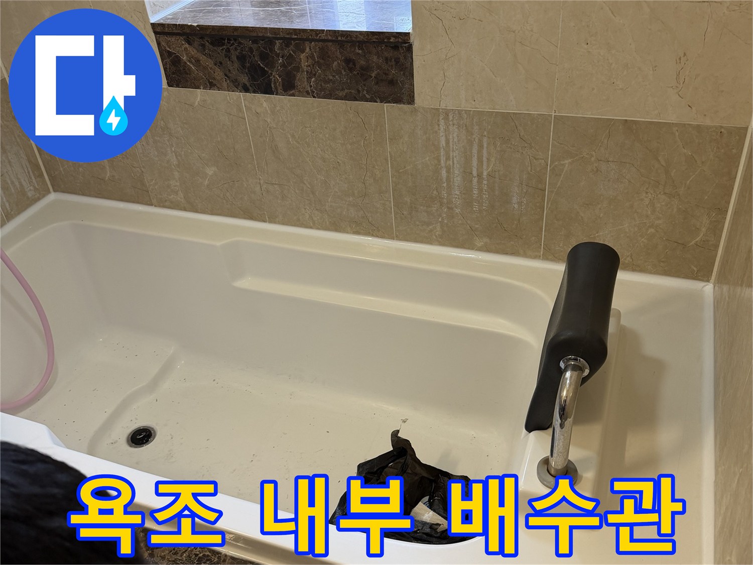 욕조 하단 배수구와 수전 주변의 마감 상태를 촬영한 사진