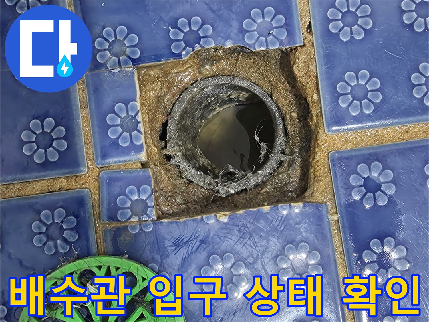 화장실 배수구-노출된 배관과 주변 타일의 균열 상태