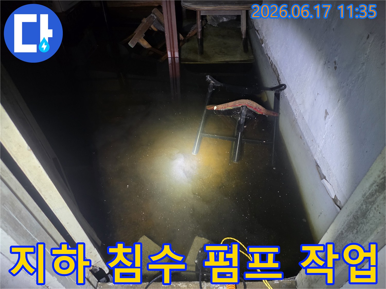 지하 침수 현장에서 물을 신속하게 제거하기 위해-배수 펌프가 작동 중인 긴급 복구 현장입니다