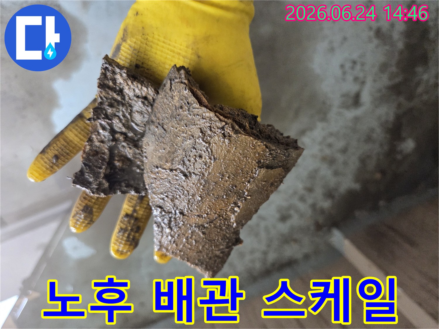 노란색-장갑을-낀-손이-오래된-수도관에서-나온-부식된-이물질-조각들을-들고-있는-모습