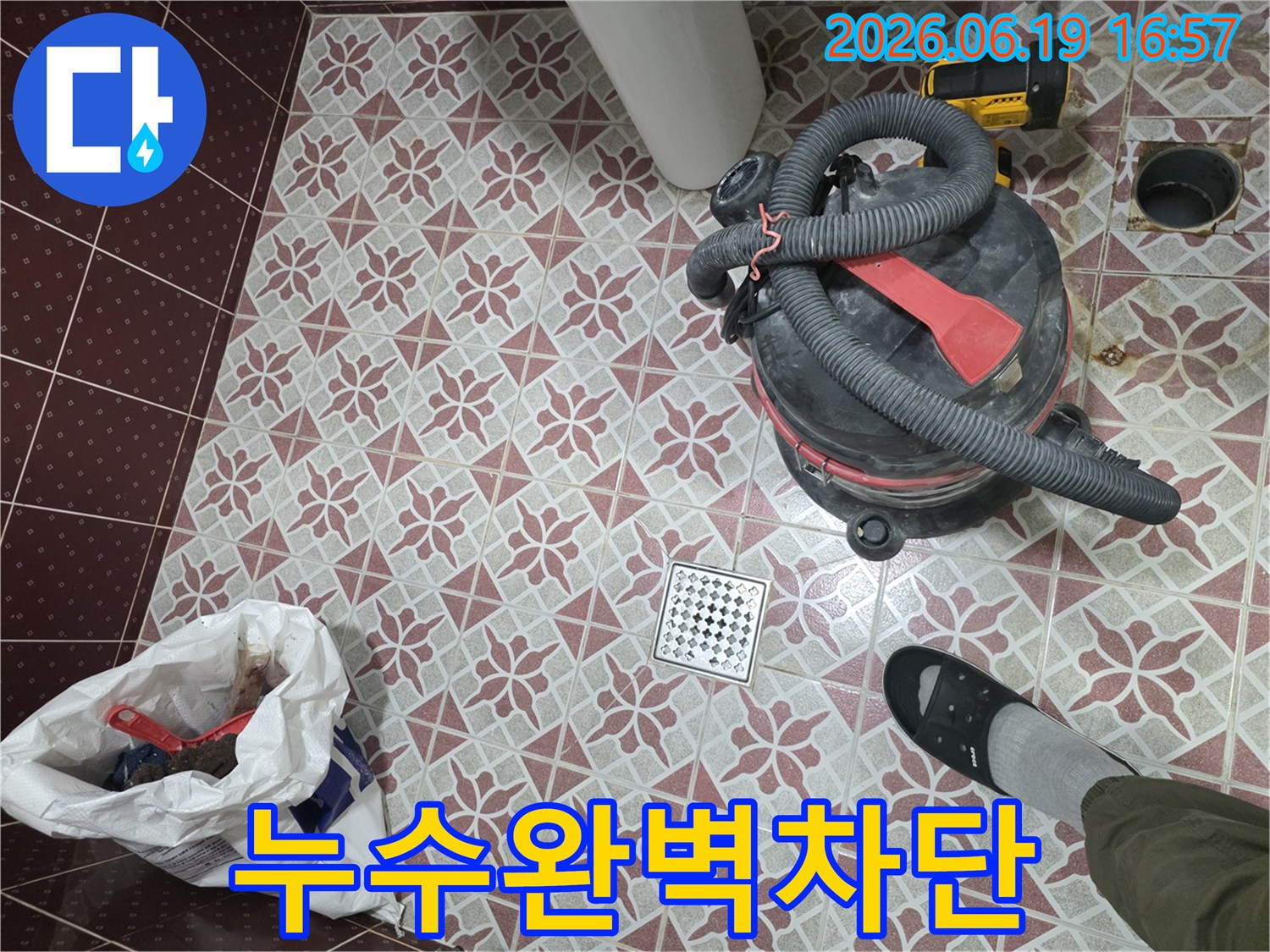 누수 문제 해결을 위한-욕실 바닥 작업 현장-습식 청소기로 물을 빨아들이고-배수구를 중심으로-정돈된 모습