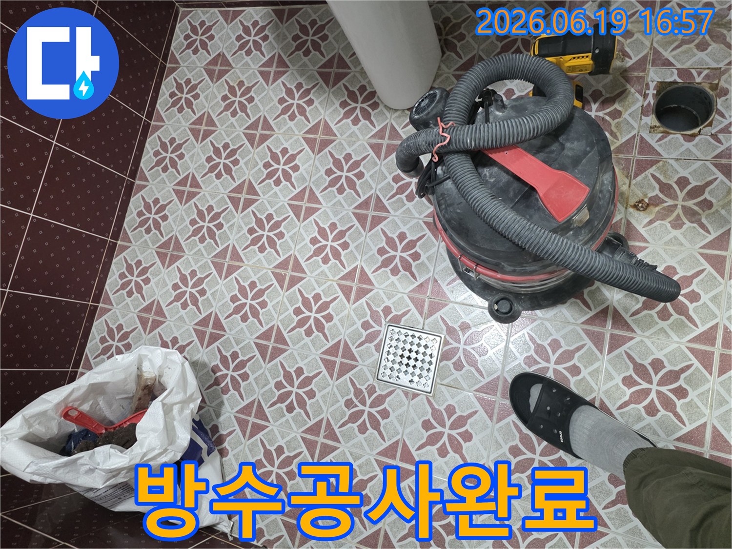 누수 공사 중-발생한 물기를 제거하고-바닥을 청결하게 유지하는 과정입니다-습식 청소기를 통해-배수구 주변의 물기를 흡입하여-건조 상태를 확보하고 있으며-이는 고객님의 만족도를 높이기 위한-필수적인 작업입니다