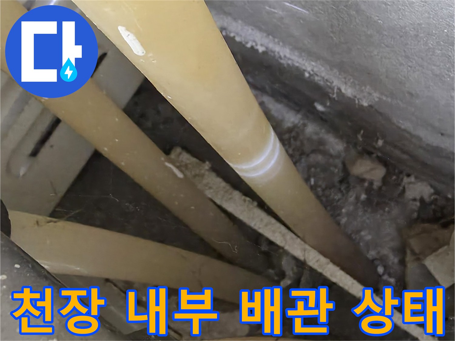 천장 점검구 내부-여러 갈래의 배관과 연결 부위가 보이는 모습