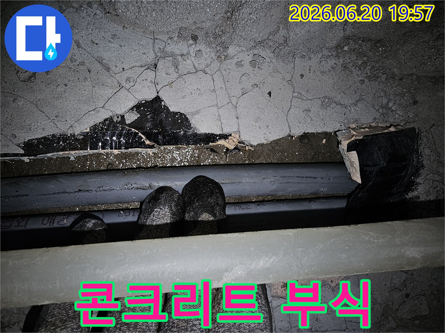 이 이미지는-주택 천장에서-누수가 발생하여-콘크리트가 부식되고-배관이 드러난-심각한 손상-현장을 보여줍니다