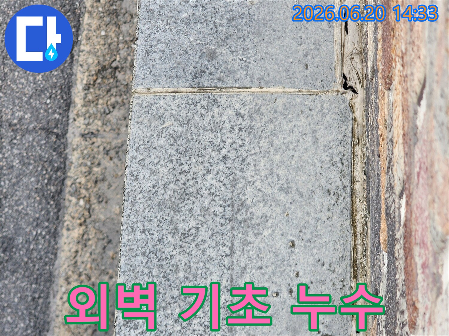 건물 외벽의 기초 부분에서-발견된 물샘 현상과-손상된 마감재