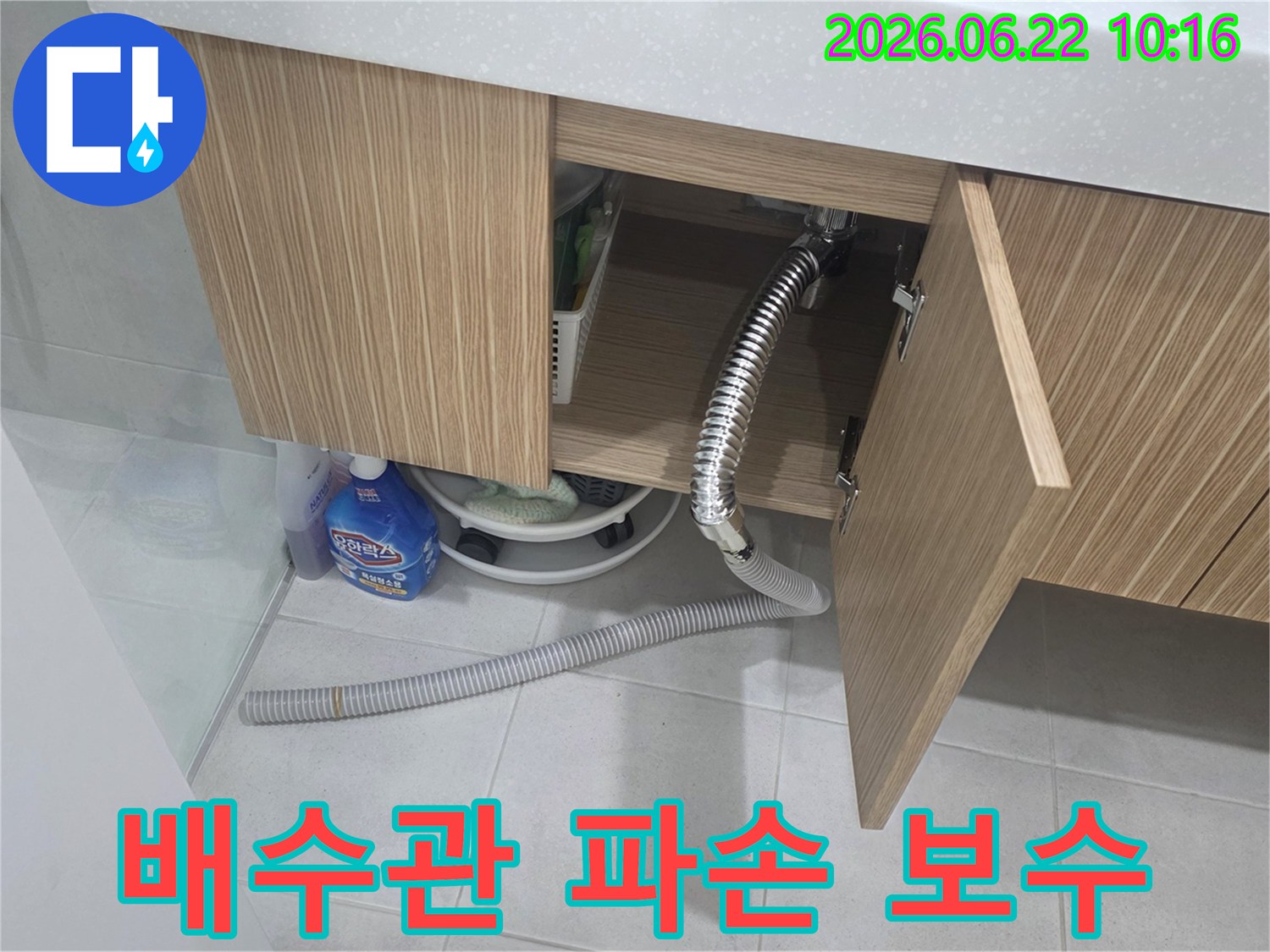세면대 하부장 아래에서 파손된 배수관으로 인해 물이 새는-긴급 보수가 필요한 현장