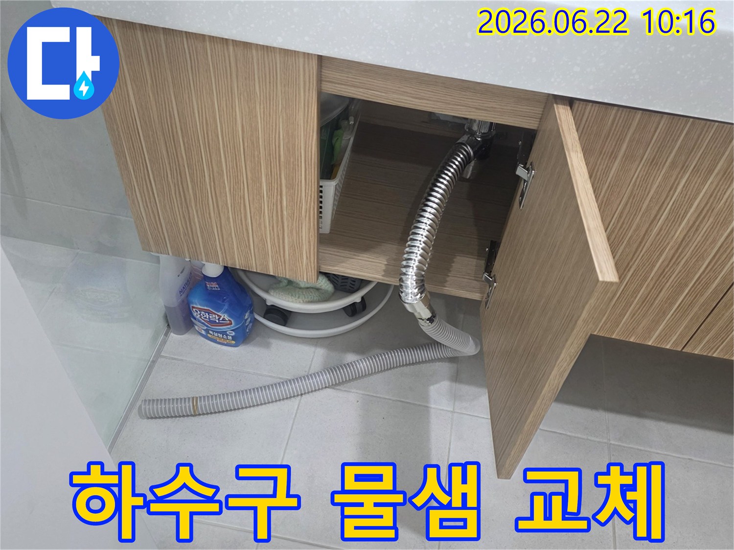 세면대 하부장 아래에서 하수구 배수 호스 문제로 인해 물이 새는-현장을 교체하여 해결하는 모습