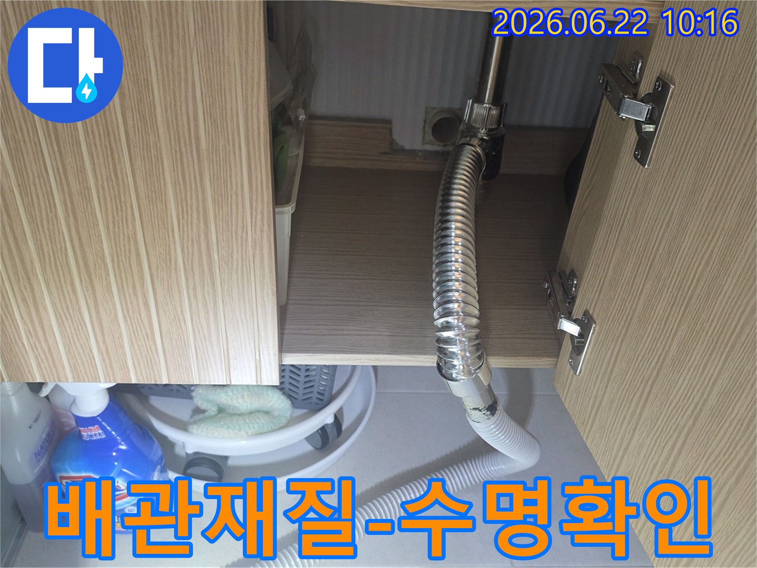 싱크대 하부 배관의 재질과 현재 상태를 확인하여-누수 발생 가능성과 교체 시기를 판단하는 장면