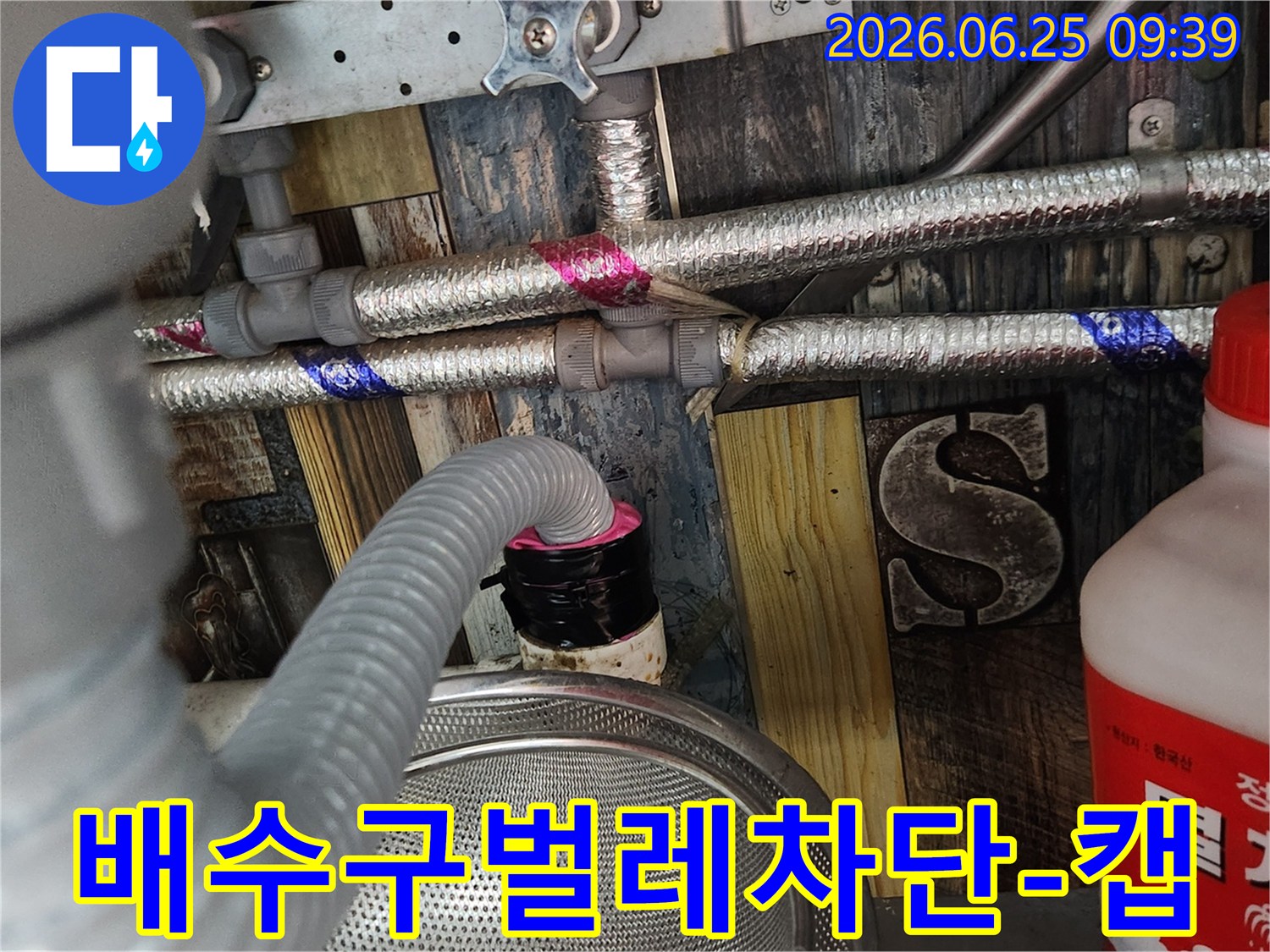 누수 전문가가 누수 공사 완료 후-세탁실 배수구에서 유입될 수 있는-벌레를 완벽하게 차단하기 위해-특수 제작된 캡을 설치하는 모습
