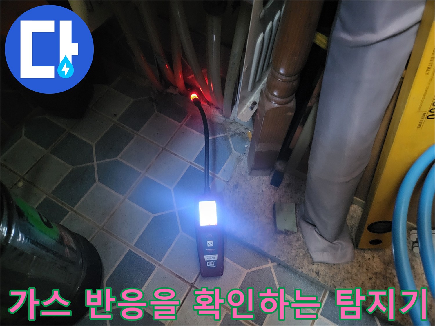 어두운 바닥 타일 위에서 작동 중인 가스 탐지 장비