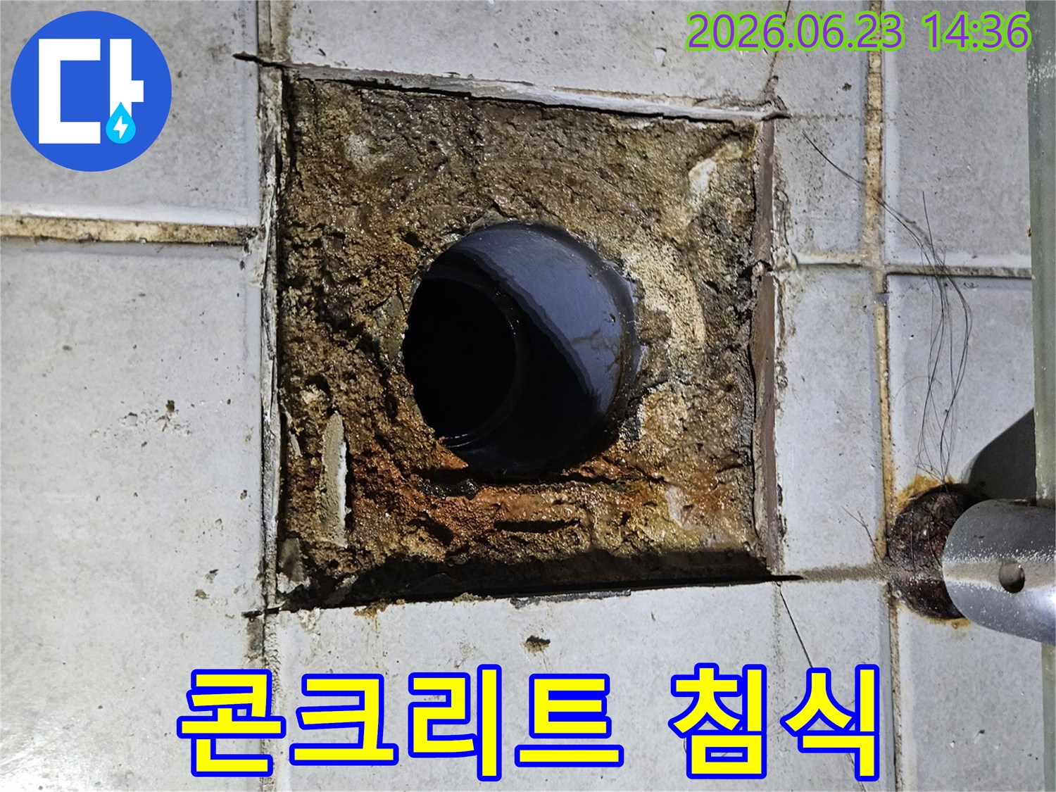 배수구 주변의 콘크리트가 누수로 인해 심하게 침식되고-타일이 파손된 모습
