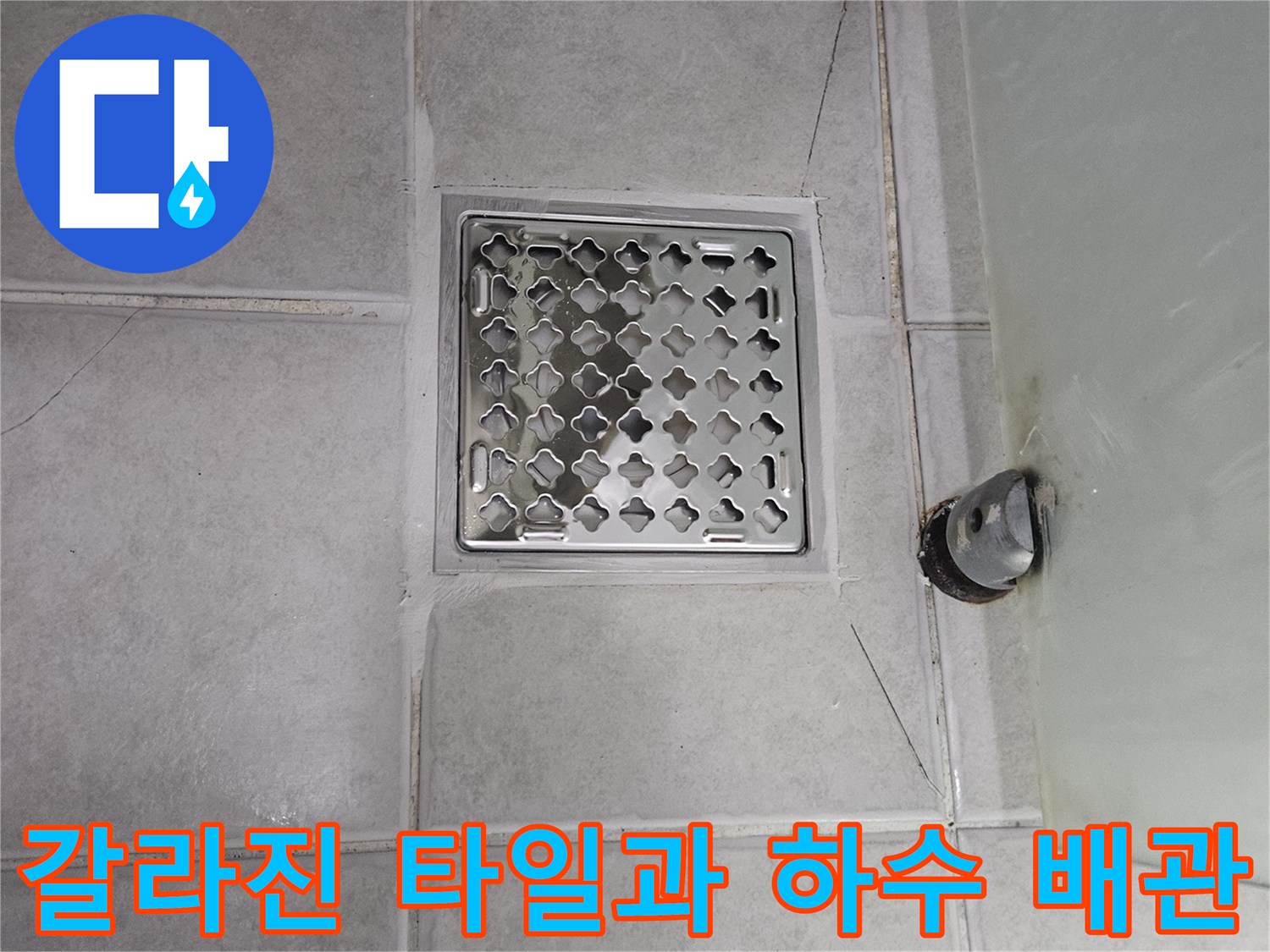 욕실 바닥면 - 배수구 주변의 균열된 타일과 배관 연결부