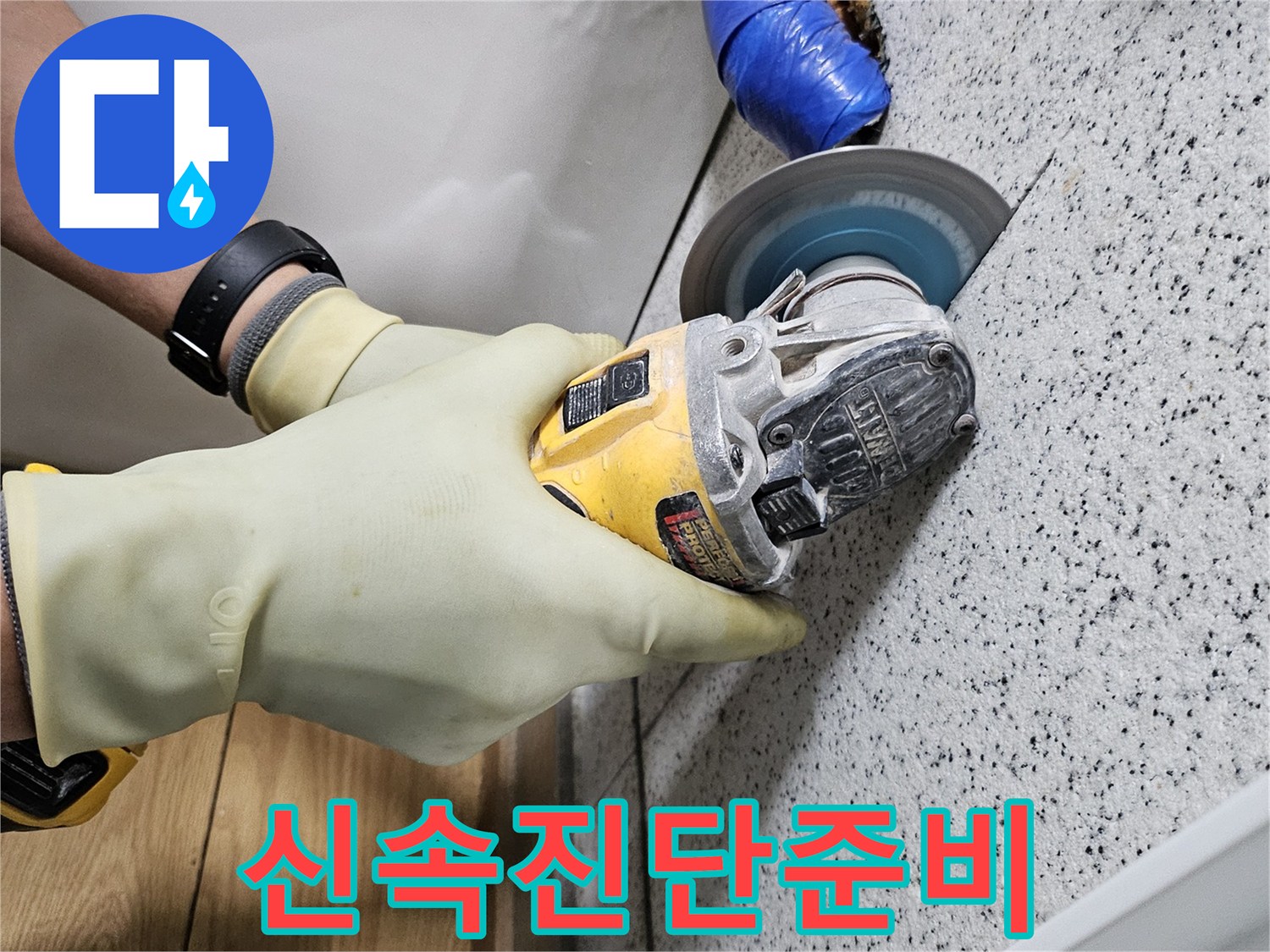 안전 장갑을 착용한 작업자가-그라인더로 천장 타일을-조심스럽게 절단하고 있습니다.