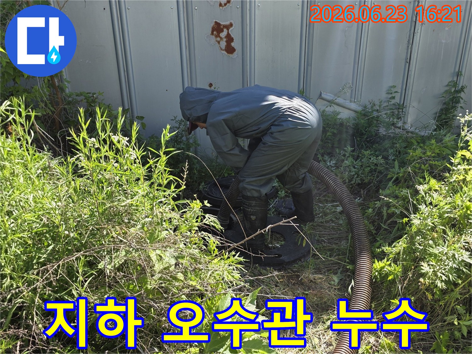 전문 작업자가 보호복을 입고 지하 오수관의 누수를 탐지하고 보수하기 위해 흡입 작업을 하는 모습