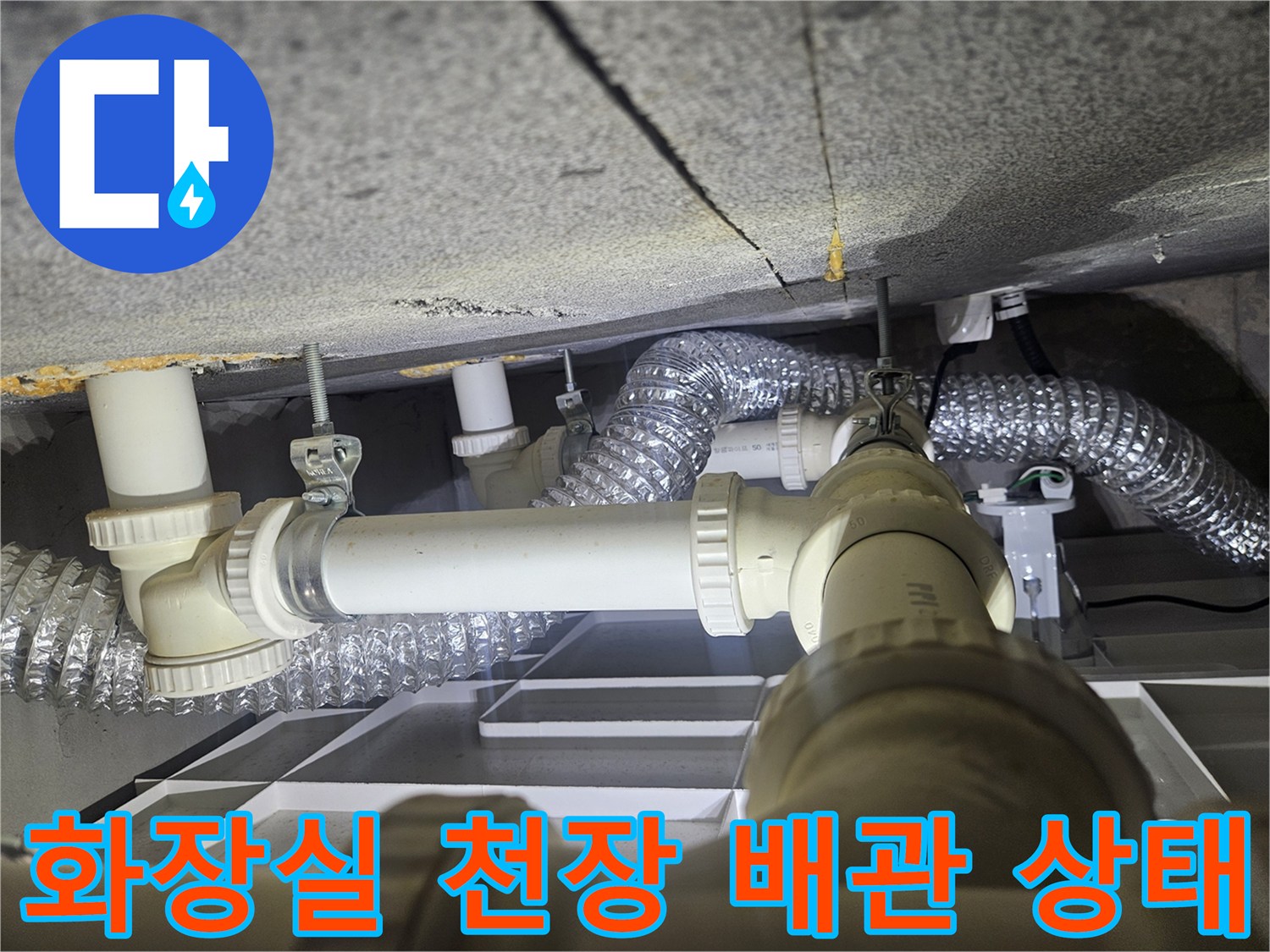 천장-슬래브-아래에-설치된-하얀색-배관과-은색-환기자재