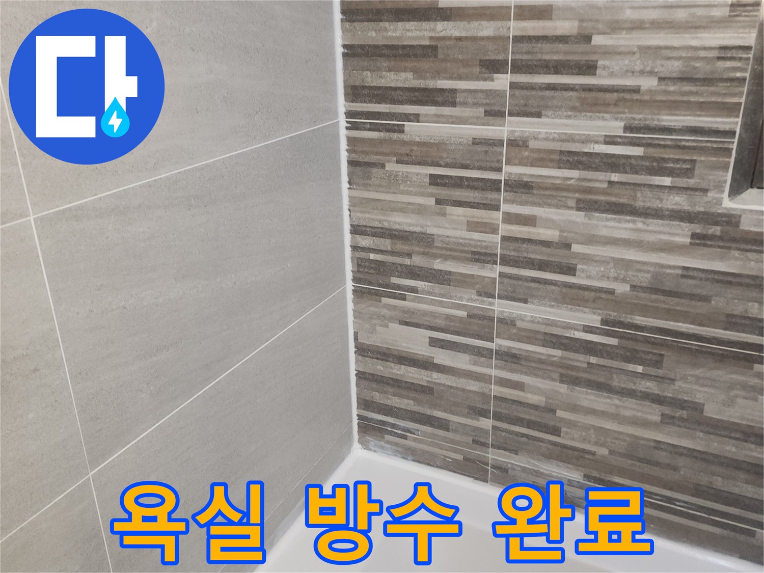 누수 공사 완료 후-새롭게 시공된 욕실 바닥과 벽면 타일-그리고 깨끗한 실리콘 마감 상태를 보여줍니다.