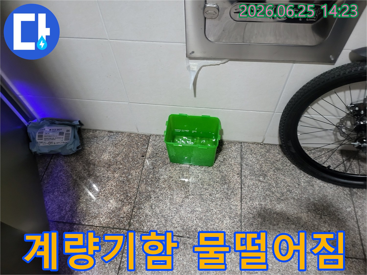 수도계량기함-아래에서-물이-새어-나와-초록색-물받이에-고이는-상황을-보여주는-누수-현장-사진