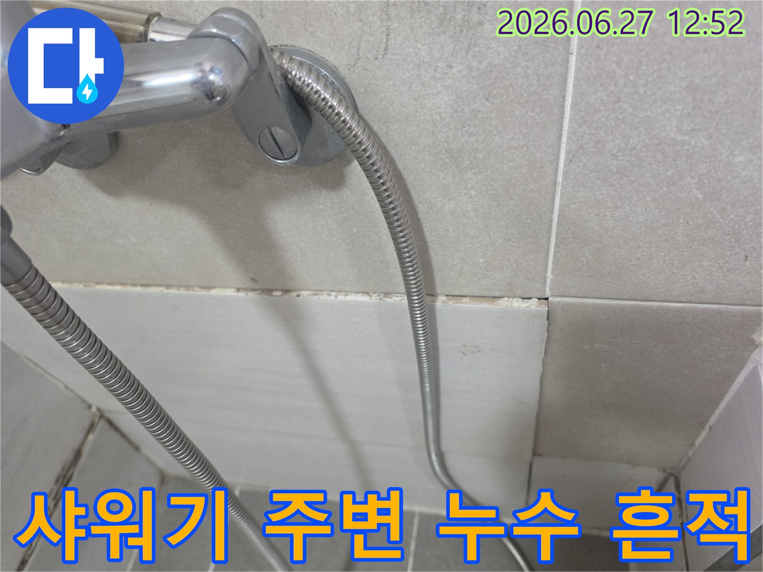 욕실 샤워기 연결부 하단 타일 줄눈에 발생한 곰팡이와-물샘 흔적을 보여주는 사진