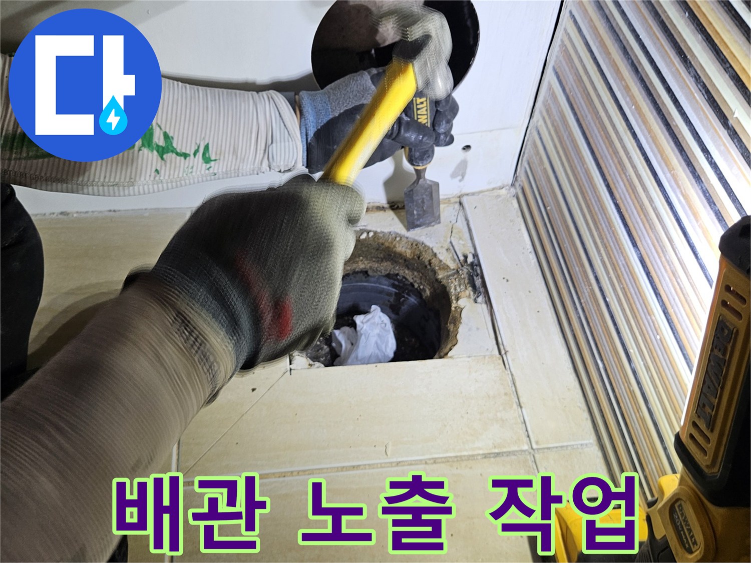 망치와 공구를 사용하여 욕조 옆면을 뚫는 누수 점검 과정