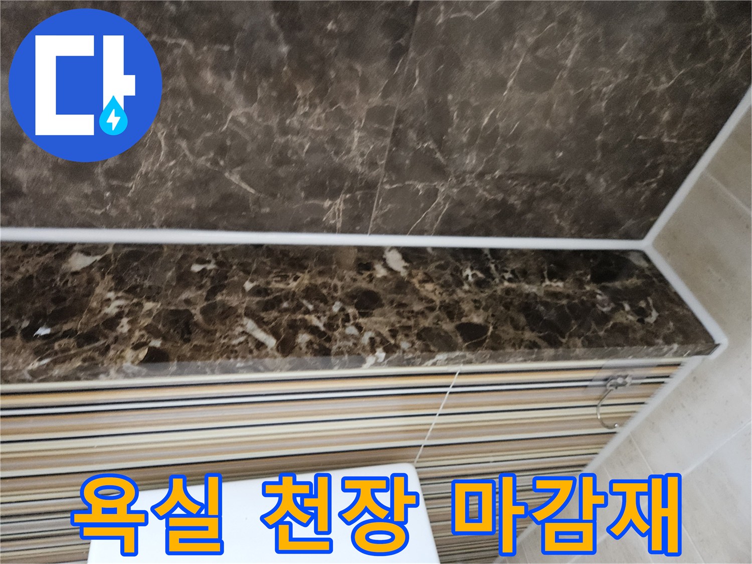 어두운 대리석 패턴의 화장실 천장 마감재 사진입니다.