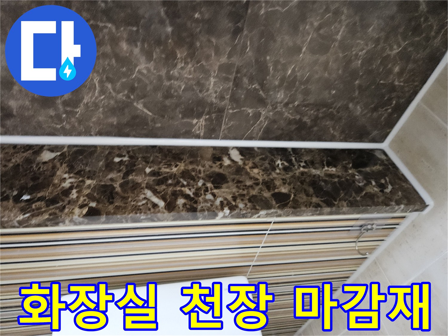 어두운색 대리석 패턴의 화장실 천장 마감 부위입니다.