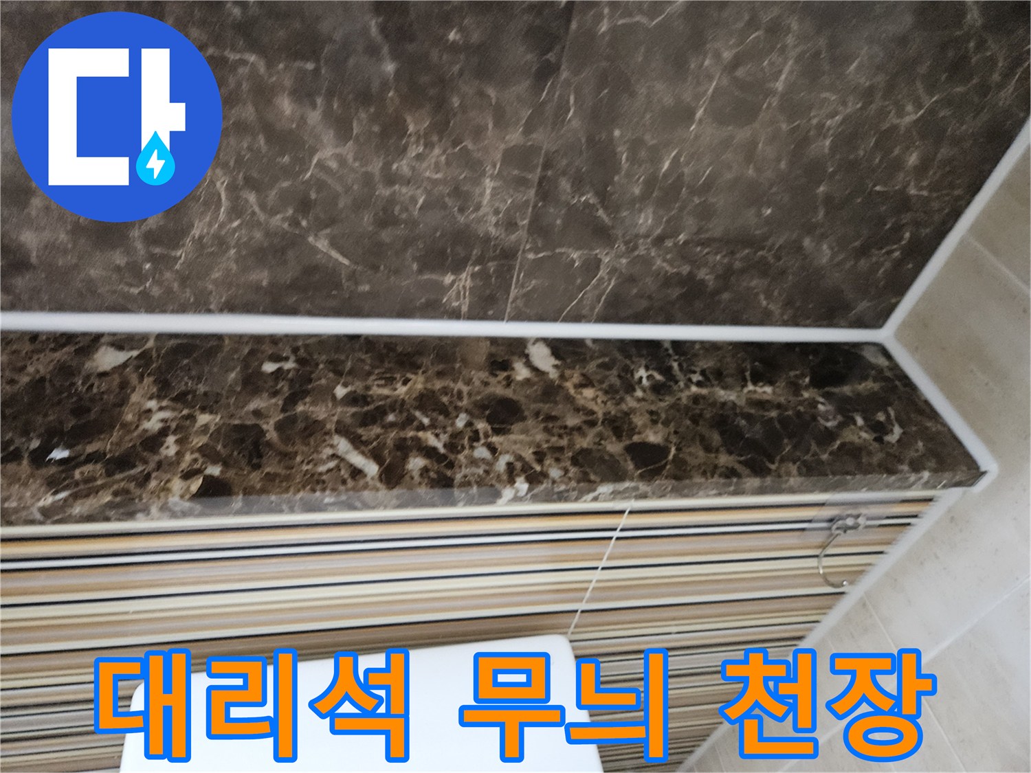 화장실 내부의 대리석 패턴 천장재 사진입니다.