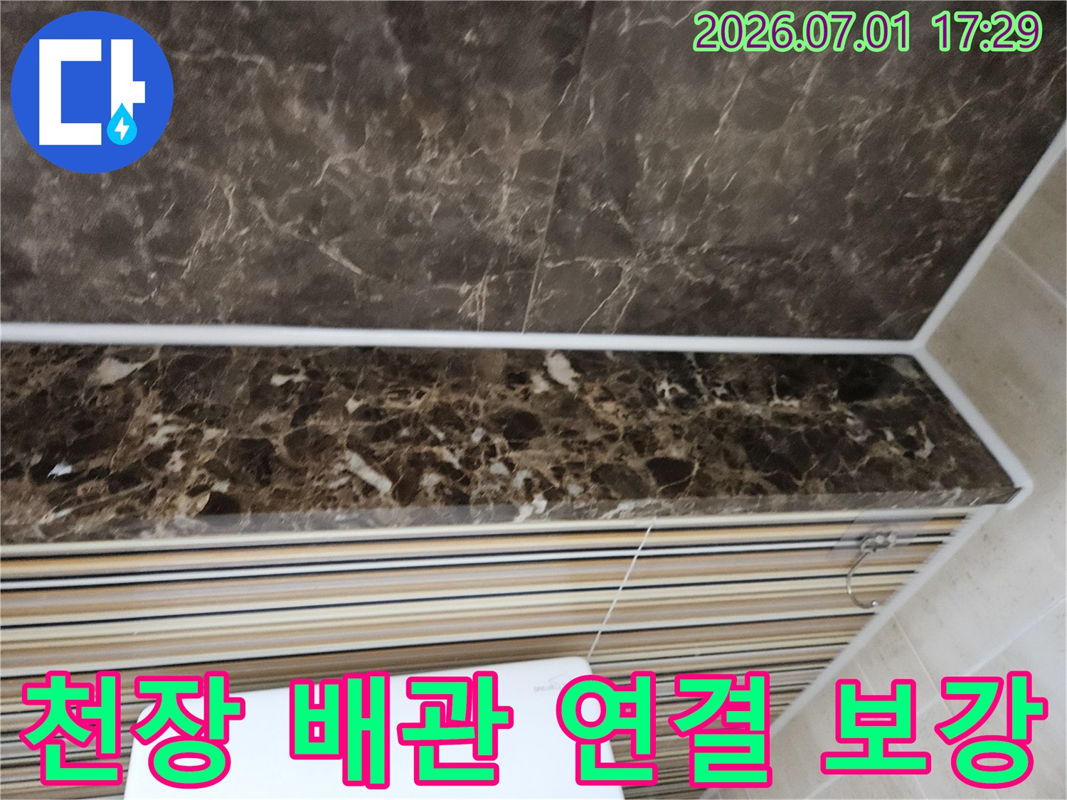 화장실 천장-배관 연결 부위에서-누수가 의심되어-보강 작업을 진행하는-현장을 촬영한 이미지입니다