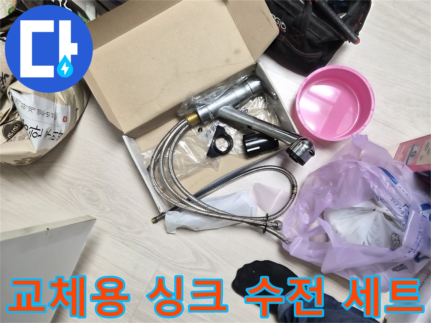 새로 설치할 은색 싱크 수전과 연결 호스 및 작업 도구