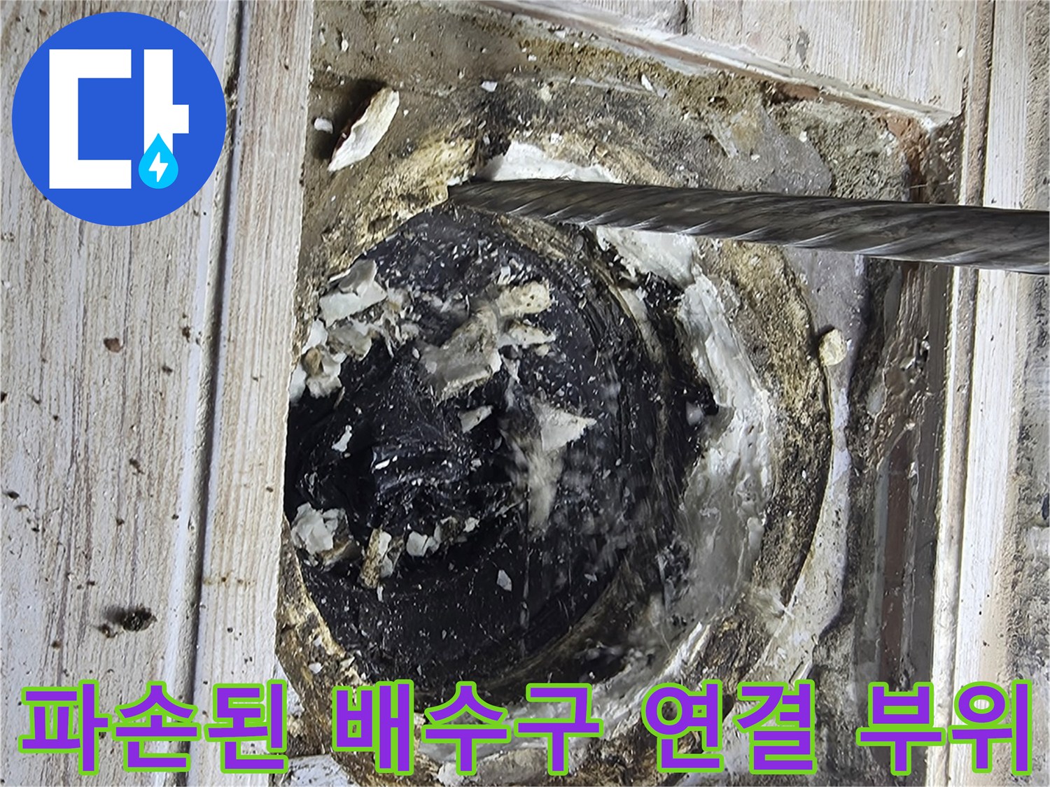 세탁실 바닥의 타일을 걷어내고 노출시킨 배수 트랩과 파손 구간