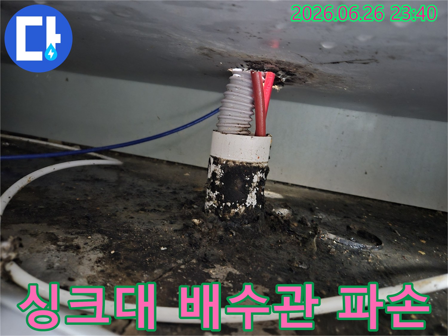 주택 싱크대 배수관 틈새에서 발생한 누수로 인해-주변이 심하게 오염되고 배수관이 파손된 모습을 보여줍니다.