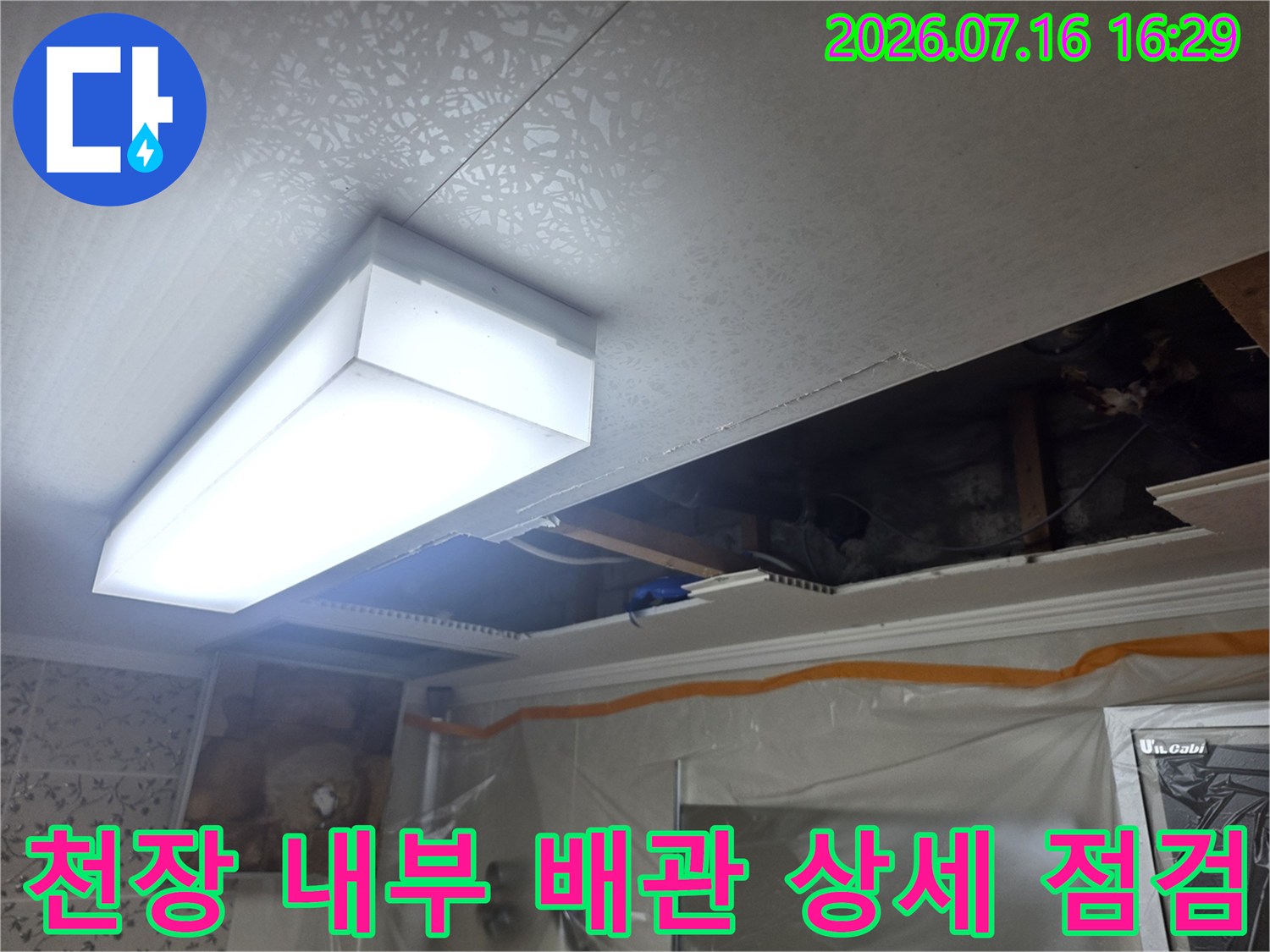 조명과 인접한 천장 안쪽 배관 연결부를 세밀하게 확인하는 모습