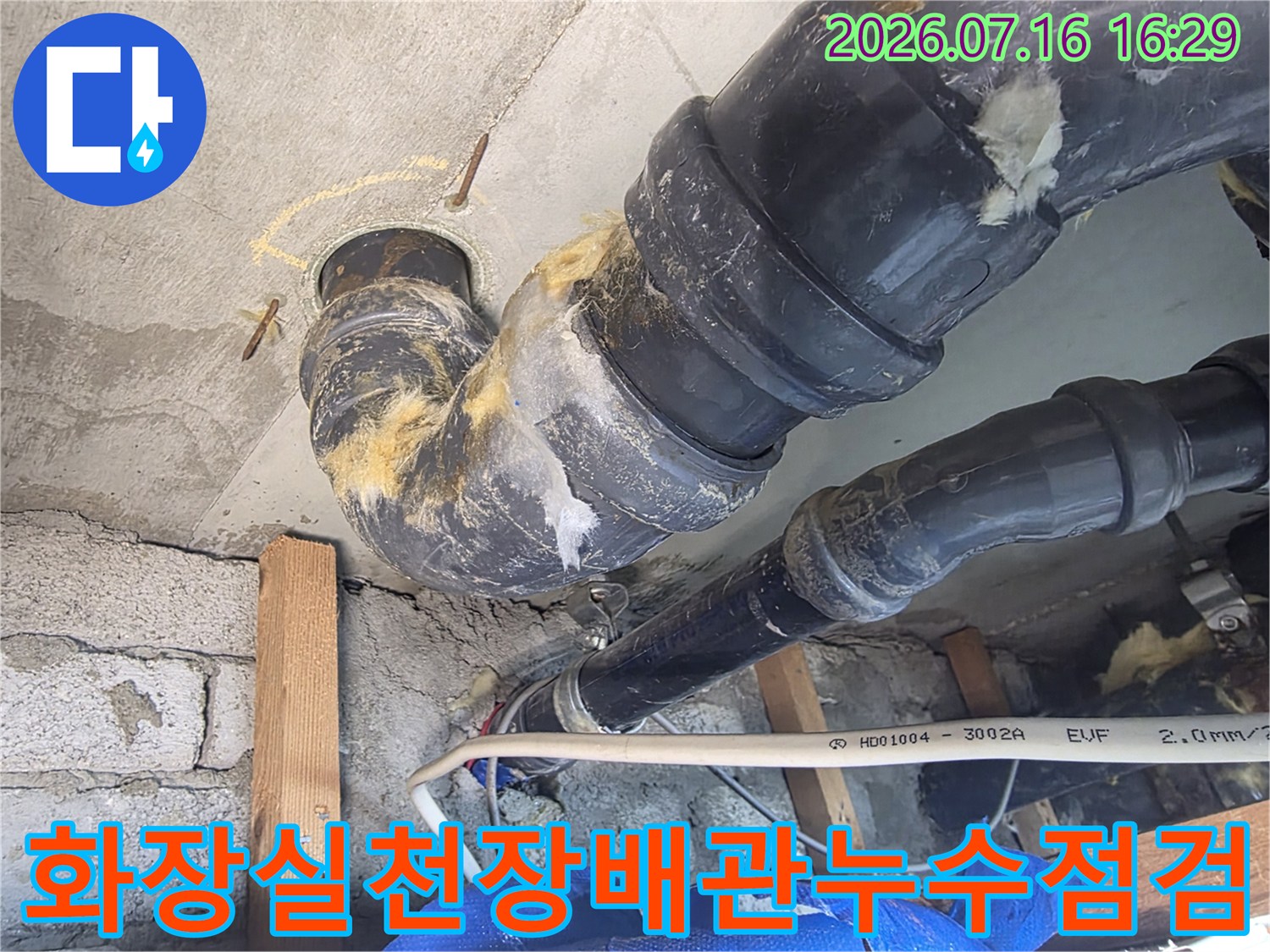 화장실 천장 내부의 노출된 배관과 누수 흔적이 있는 연결 부위 점검 모습