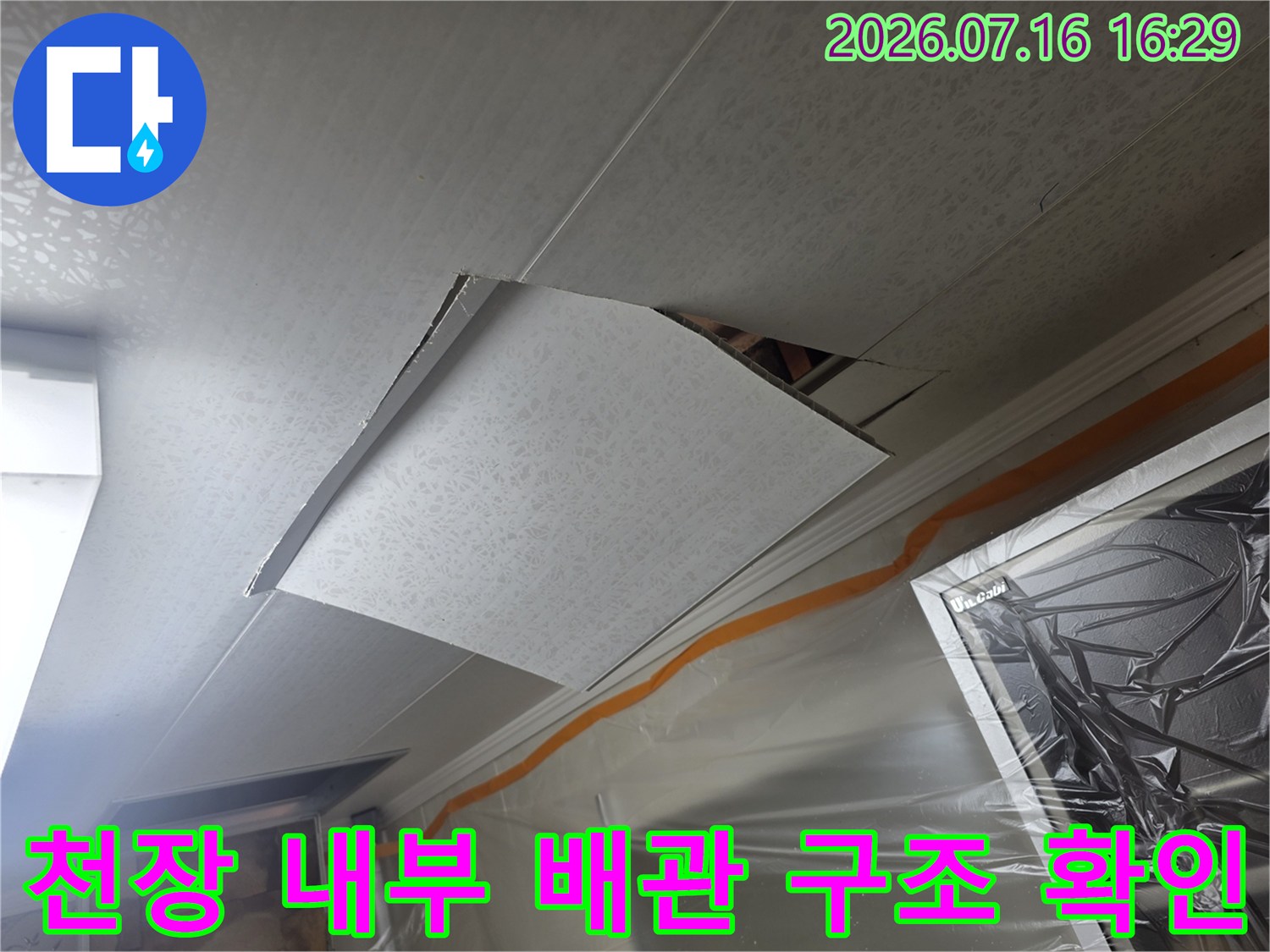 화장실 천장 안쪽 마감재를 제거하고 배관 부위를 점검하는 장면