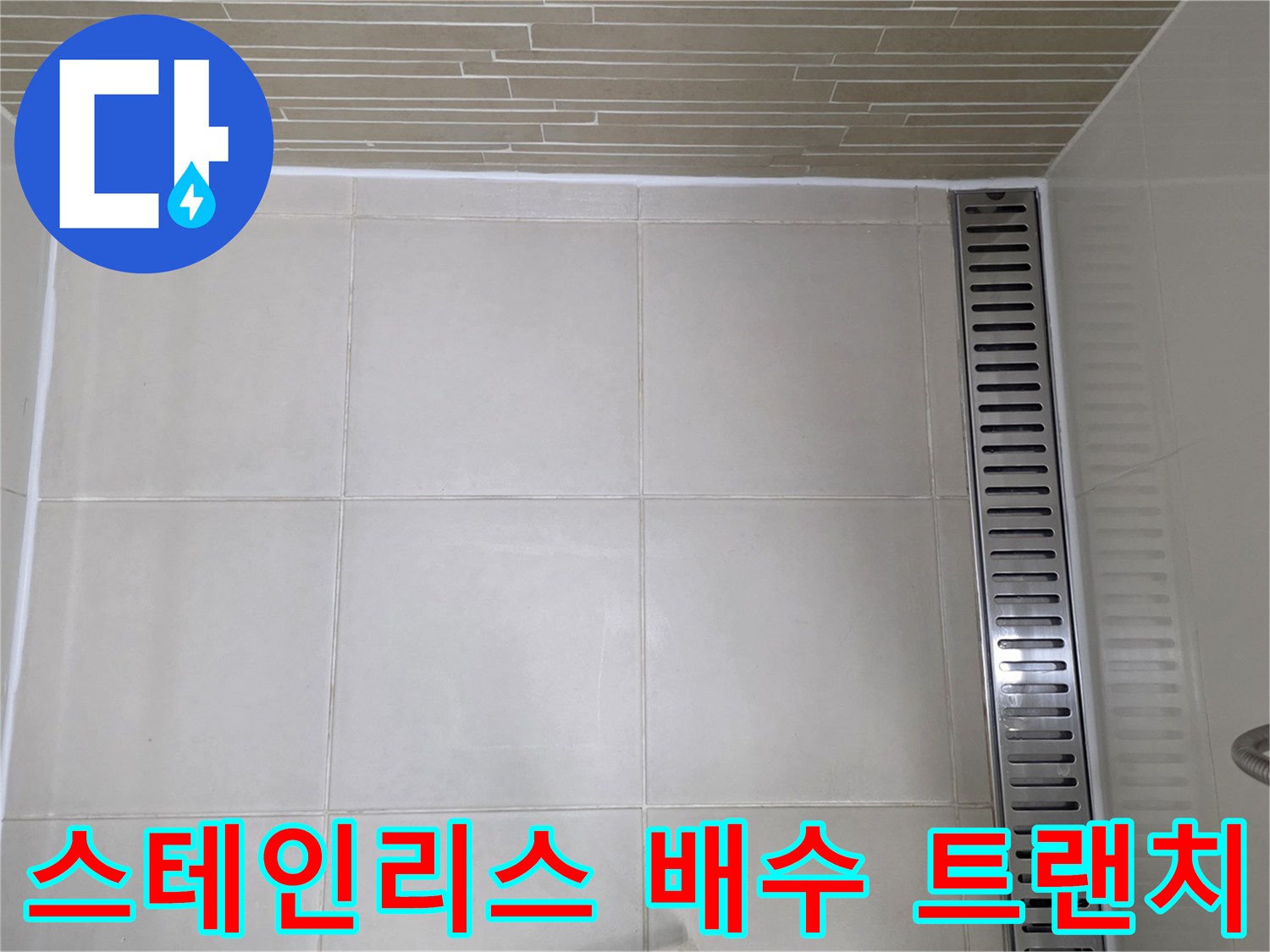 바닥 타일 사이에 길게 설치된 스테인리스 배수 트렌치 사진