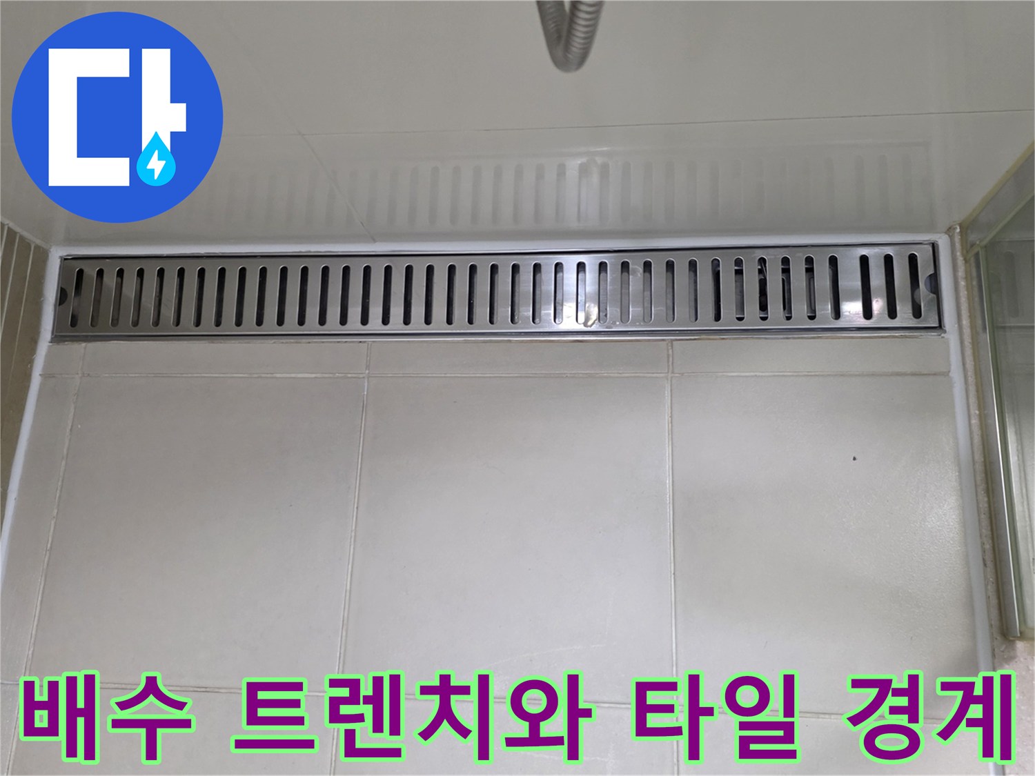 하얀 타일 바닥과 스테인리스 배수구의 접합부