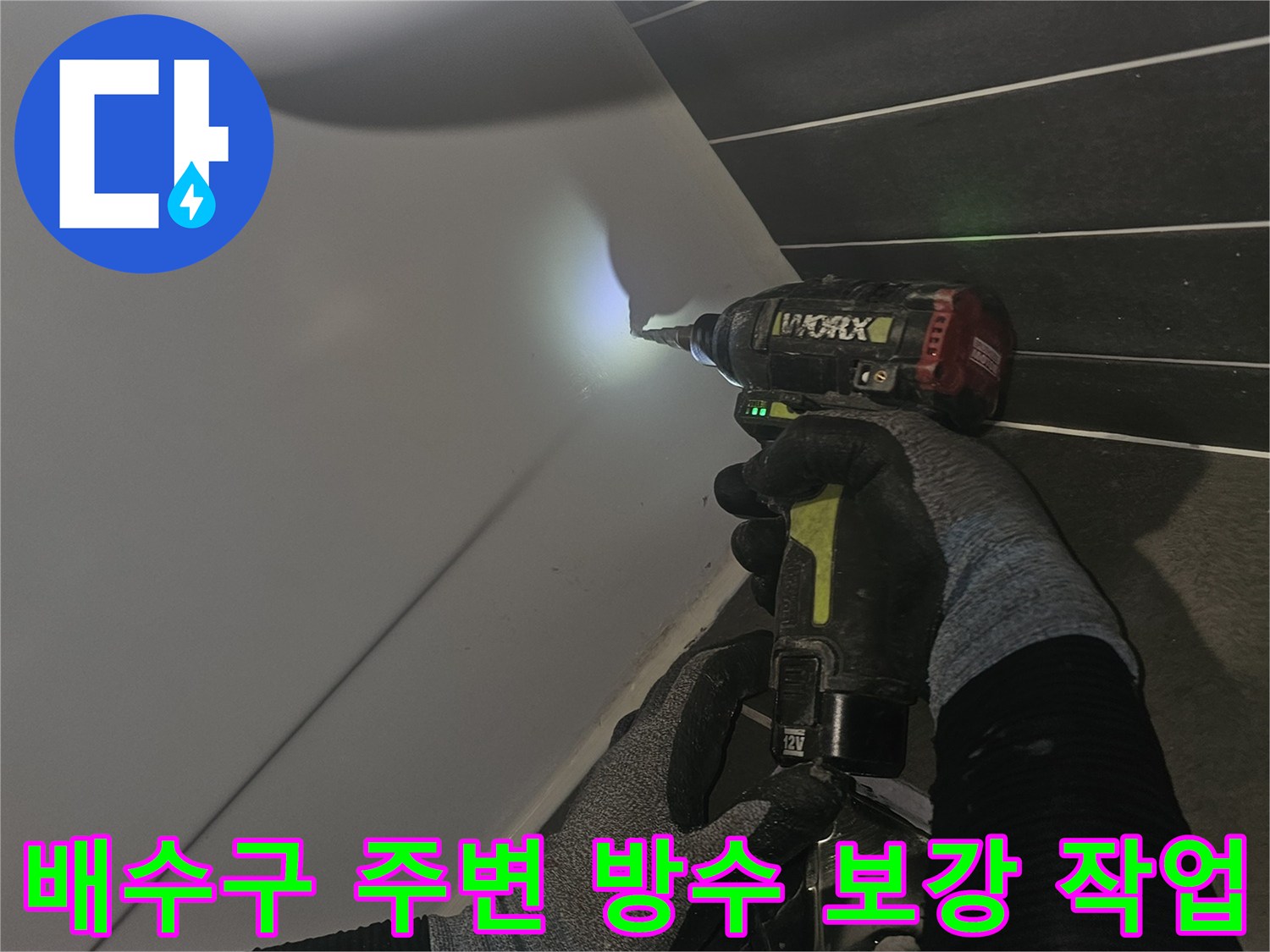 전동 드릴을 사용하여-배수구 주변의 틈새를 메우기 위해-방수재 도포 전 정리를 진행하는 모습입니다.