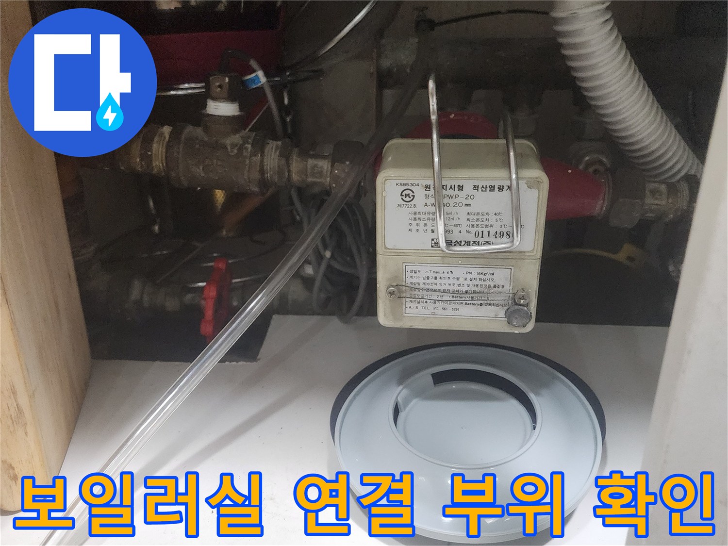 보일러 하단부의 밸브와 호스 연결 상태를 촬영한 사진